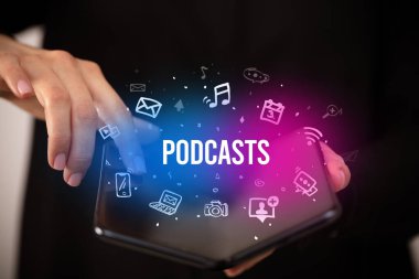 Podcast yazıları ve sosyal medya konsepti olan katlanabilir bir akıllı telefon tutan bir iş adamı
