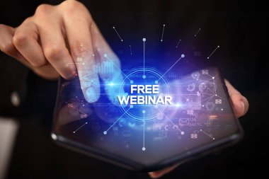 İş adamı katlanabilir bir akıllı telefon tutuyor, üzerinde Free Webinar yazıları var, yeni iş konsepti.