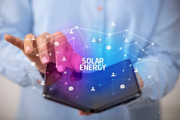 持可折叠智能手机的商人 带有太阳能题词 新技术概念 — 图库照片