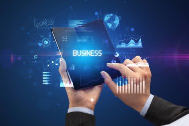 İş adamı elinde katlanabilir bir akıllı telefon tutuyor. İş dünyası yazıtları, başarılı bir iş konsepti.