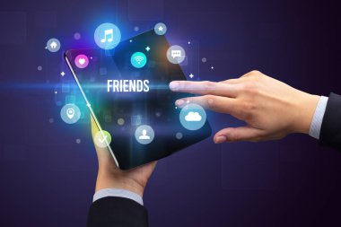 İş adamı elinde Friends yazısıyla katlanabilir bir akıllı telefon tutuyor, sosyal medya kavramı