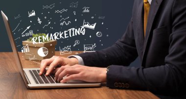 İşadamı, Remarketing yazıtları ve modern iş konseptiyle dizüstü bilgisayarda çalışıyor.