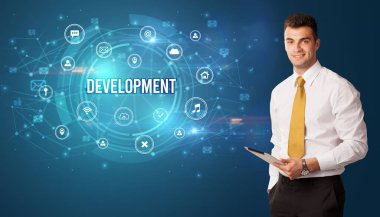 Teknolojiyle ilgili ikonlar ve DEVELOPMENT yazıtları ve modern teknoloji kavramı önünde düşünen iş adamı
