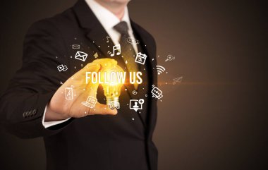 FOLLOW ABD yazıtları ve sosyal medya kavramına sahip bir iş adamı elinde ampul tutuyor