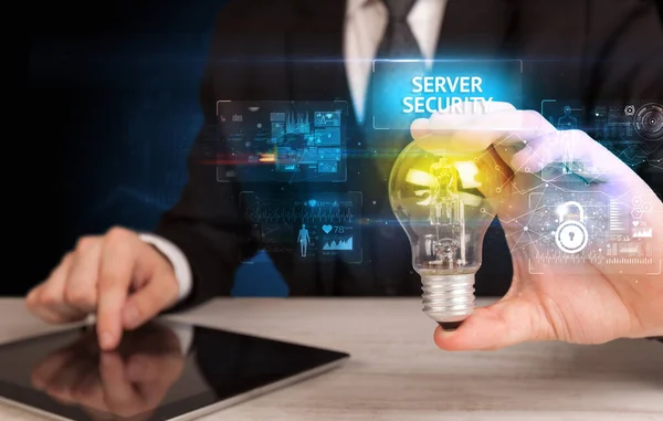 Server Securityの碑文を持つ電球を保持するビジネスマン オンラインセキュリティのアイデアのコンセプト — ストック写真