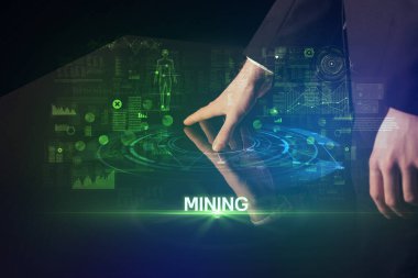 İşadamı, MINING yazıtı ve modern teknoloji konseptiyle büyük ekrana dokunuyor