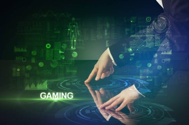 İşadamı büyük ekrana GAMING yazısıyla dokunuyor, modern teknoloji konsepti.