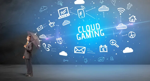 Businessman defending with umbrella from CLOUD GAMING inscription, modern technology concept