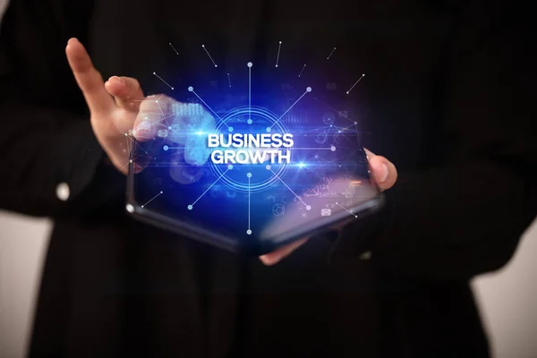 Affärsman Som Innehar Vikbar Smartphone Med Business Growth Inskription Affärsidé — Stockfoto