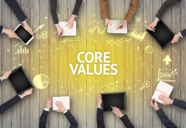 CORE VALUES yazıtları olan bir ofiste çalışan Meşgul İnsanlar Grubu, başarılı iş konsepti