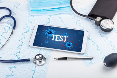 Beyaz yüzeyde TEST yazıtı, salgın konsepti içeren tablet pc ve doktor araçları
