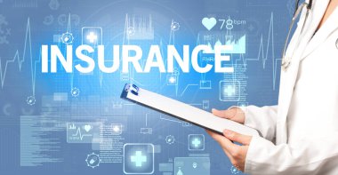 Genç doktor INSURANCE yazıtları ve sağlık konseptiyle notlar yazıyor.