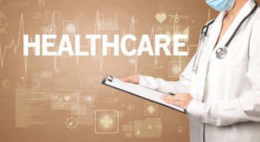 Genç doktor, sağlık hizmetleri konsepti ve sağlık sigortası yazısıyla notlar yazıyor.