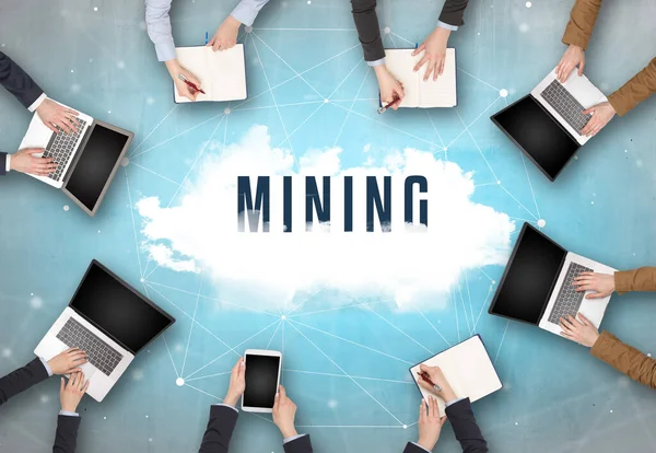 Group of people having a meeting with MINING insciption, web security concept