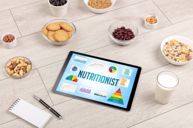 Organik gıda ve tablet bilgisayarı NUTRITIONIST yazısını, sağlıklı besin bileşimini gösteriyor