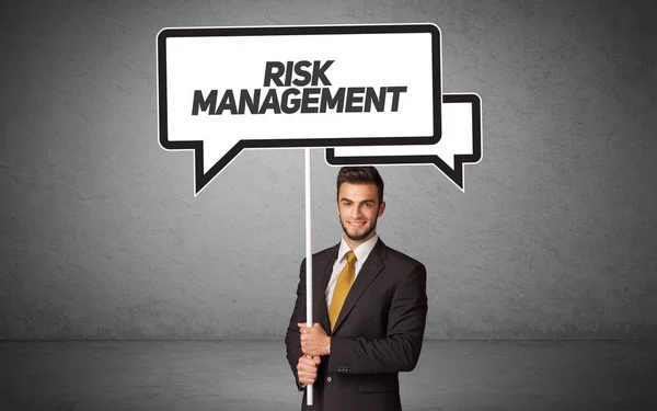 stock image Young business person in casual holding road sign with RISK MANAGEMENT inscription, new business idea concept