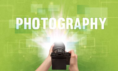 Fotografik yazı ve seyahat konseptiyle el ele tutuşan dijital kameranın yakın çekimi