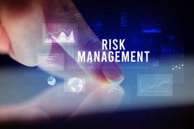 Tablete çizelgeler ve RISK MANAGEMENT yazıtları ile dokunmak, iş konsepti