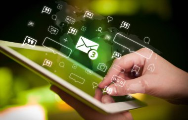 Yeni mesaj simgeleri içeren tablet kullanan bir elin yakın plan görüntüsü, sosyal medya kavramı