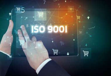 ISO 9001 yazıtlı, çevrimiçi alışveriş kavramına sahip bir el tutma tabletinin yakın çekimi