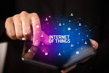 İş adamı elinde, üzerinde yeni teknoloji kavramı ve yazıtların olduğu katlanabilir bir akıllı telefon tutuyor.
