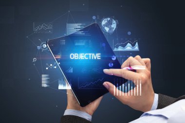 İş adamı elinde objektif yazıtlı, başarılı bir iş konsepti olan katlanabilir bir akıllı telefon tutuyor.