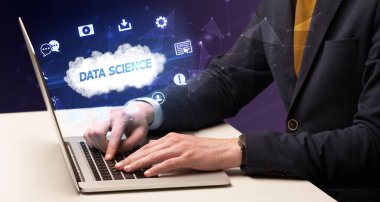 Bilgisayar üzerinde Data Science yazıtları ve modern teknoloji konseptiyle çalışan bir iş adamı