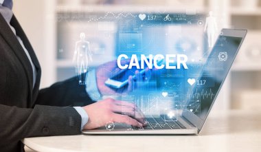 Doktor, CANCER yazısıyla sağlık kontrolü yapıyor, tıbbi test sonuçlarını kaydediyor.