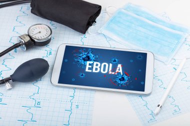 Beyaz yüzeyde EBOLA yazıtları, salgın konsepti olan tablet bilgisayar ve doktor araçları