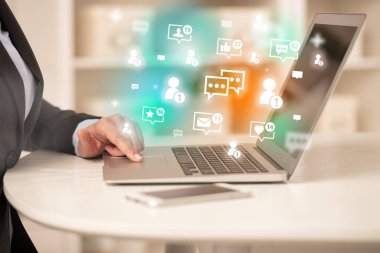 Sohbet simgeleriyle dizüstü bilgisayarda sörf yapan genç kişi, sosyal medya kavramı