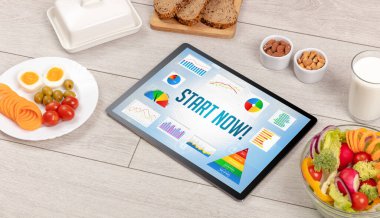 Organik gıda ve tablet bilgisayarı START Now yazısını, sağlıklı beslenme bileşimini gösteriyor