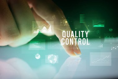 Grafikler ve Kalite Kontrol yazıt, iş kavramı ile parmak dokunma tablet