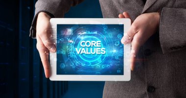 Tablet üzerinde çalışan genç iş adamı ve yazıyı gösteriyor: CORE VALUES, iş konsepti