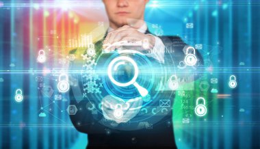 İş adamı elinde büyüteç simgesi ve etrafında birden fazla teknoloji sembolü tutuyor.