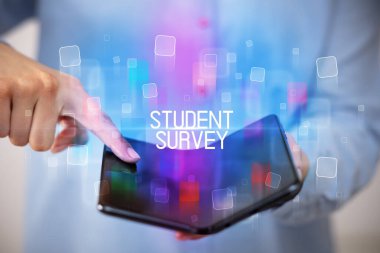 Katlanabilir bir akıllı telefon tutan genç adam ÖĞRETİM SURVEY yazıt, eğitim konsepti