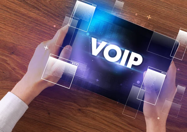 stock image Close-up of a hand holding tablet with VOIP abbreviation, modern technology concept
