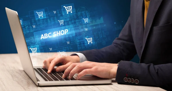 在带有Abc Shop铭文的笔记本电脑上工作的商人 网上购物概念 — 图库照片