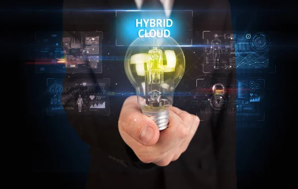 ハイブリッドクラウドの碑文と電球を保持ビジネスマン オンラインセキュリティのアイデアのコンセプト — ストック写真