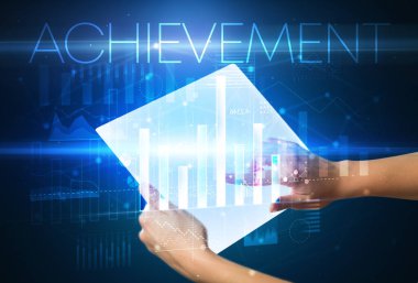 Üzerinde AKİEVEMENT yazıtları olan fütürist tablet, modern iş konsepti.