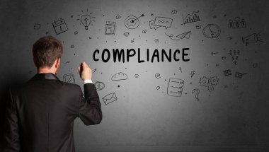 İş adamı, COMPLIANCE yazıtları ve iş stratejisi konseptiyle yaratıcı bir fikir çizimi yapıyor.