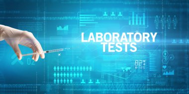 Doktorların yakından bakınca, LABORATORY TESTS yazıtları, sağlık ve tıbbi konsept içeren bir şırınga tutan beyaz bir eldiven giydiklerini görüyoruz.
