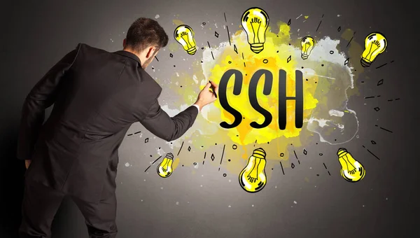 stock image businessman drawing colorful light bulb with SSH abbreviation, new technology idea concept