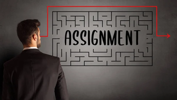 businessman drawing maze with ASSIGNMENT inscription, business education concept