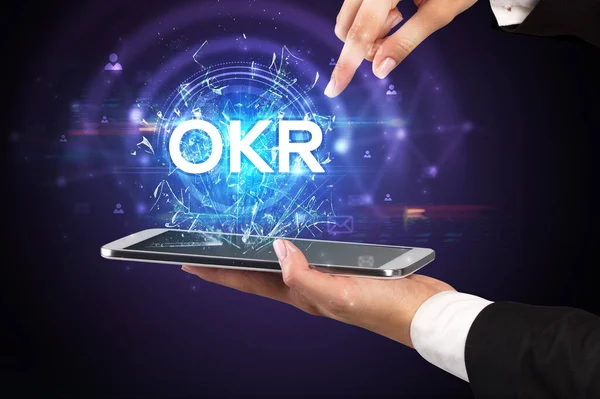 stock image Close-up of a touchscreen with OKR abbreviation, modern technology concept