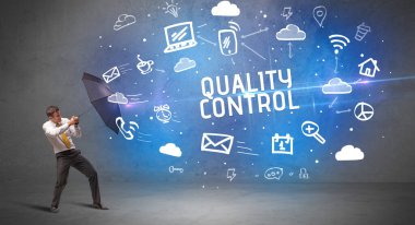 Şemsiyeyle savunma yapan iş adamı KALİTİLİK KONTROL yazıtları, modern teknoloji kavramı