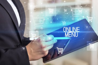 Genç kişi ONLINE MENU yazısıyla çevrimiçi alışveriş uygulaması üzerinden alışveriş yapıyor