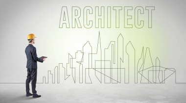 Elinde ARCHITECT yazıtları, mühendisliği ve mimari konsepti olan sağlam şapkalı bir işadamı.