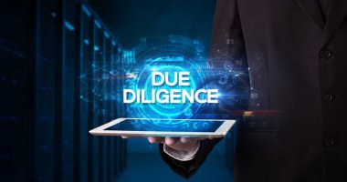 Tablet üzerinde çalışan genç iş adamı ve yazıyı gösteriyor: DUE DILIGENCE, business concept
