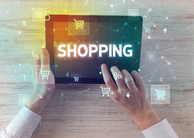 Alışveriş yazıtları ve online alışveriş konseptiyle el ele tutuşma tabletinin yakın çekimi