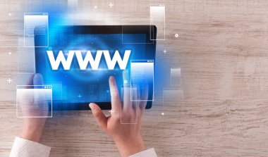 WWW kısaltmalı el ele tutuşma tableti, modern teknoloji konsepti.